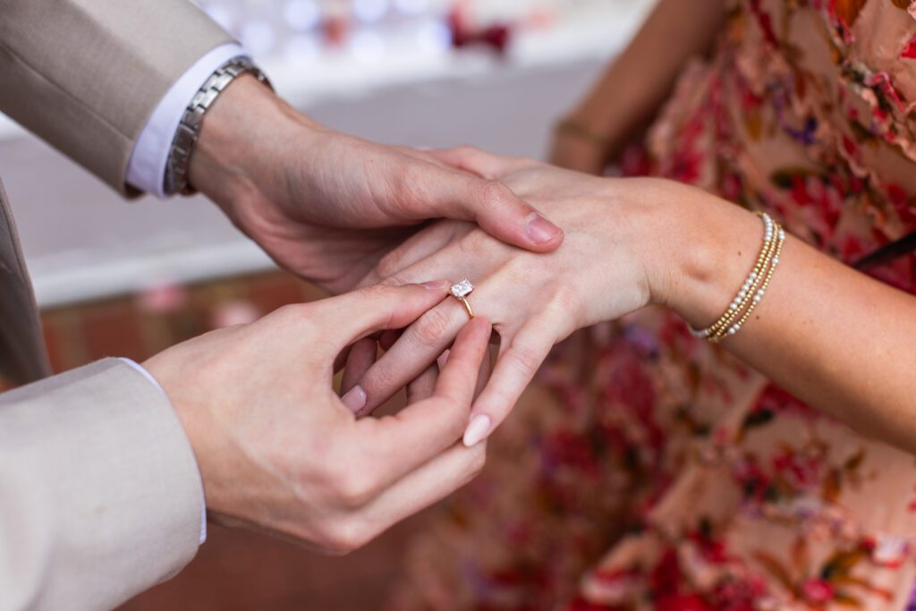 Ring on hand with couple in the background at Partridge Inn